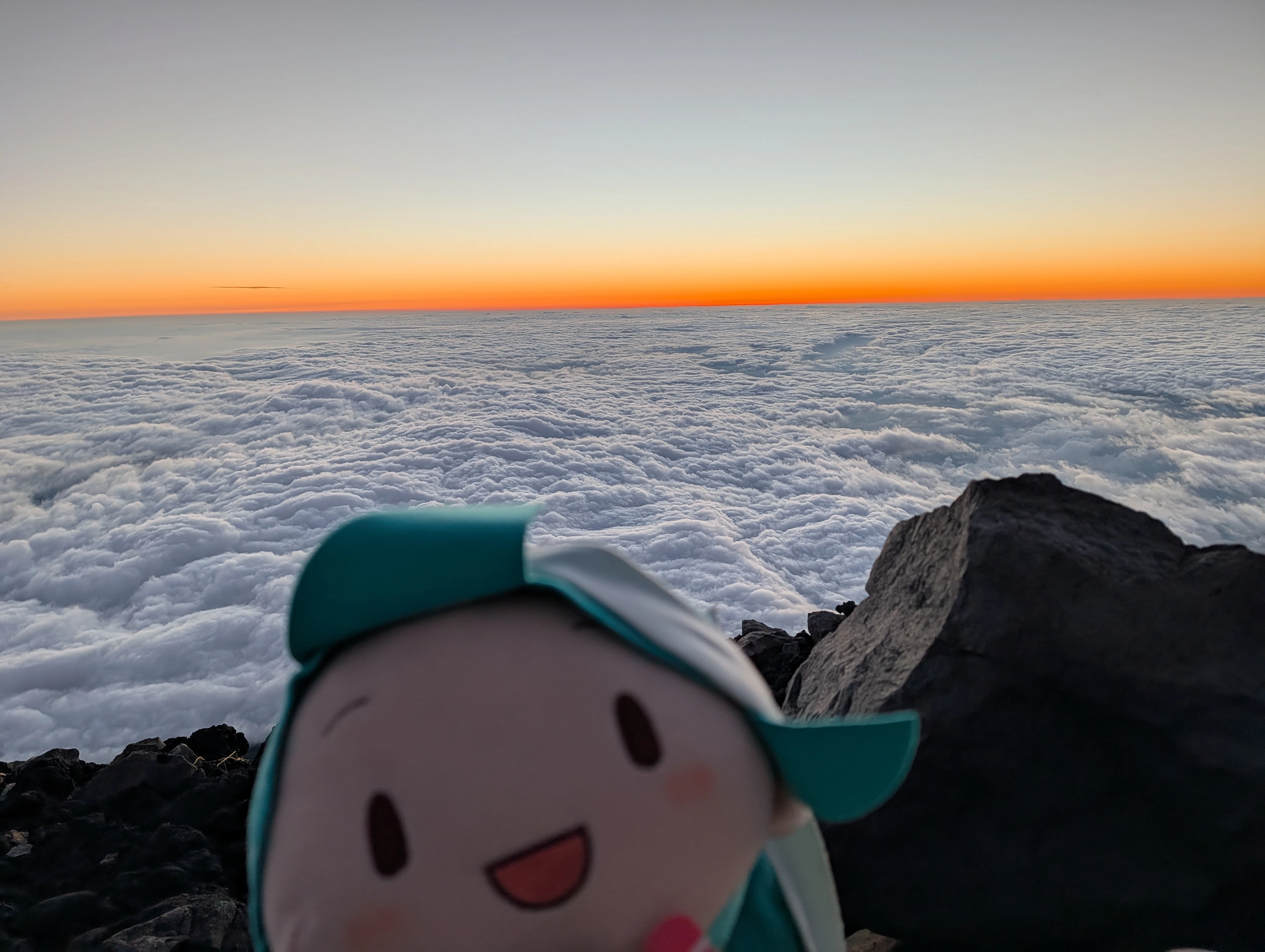 初音玩偶與日出前的雲海